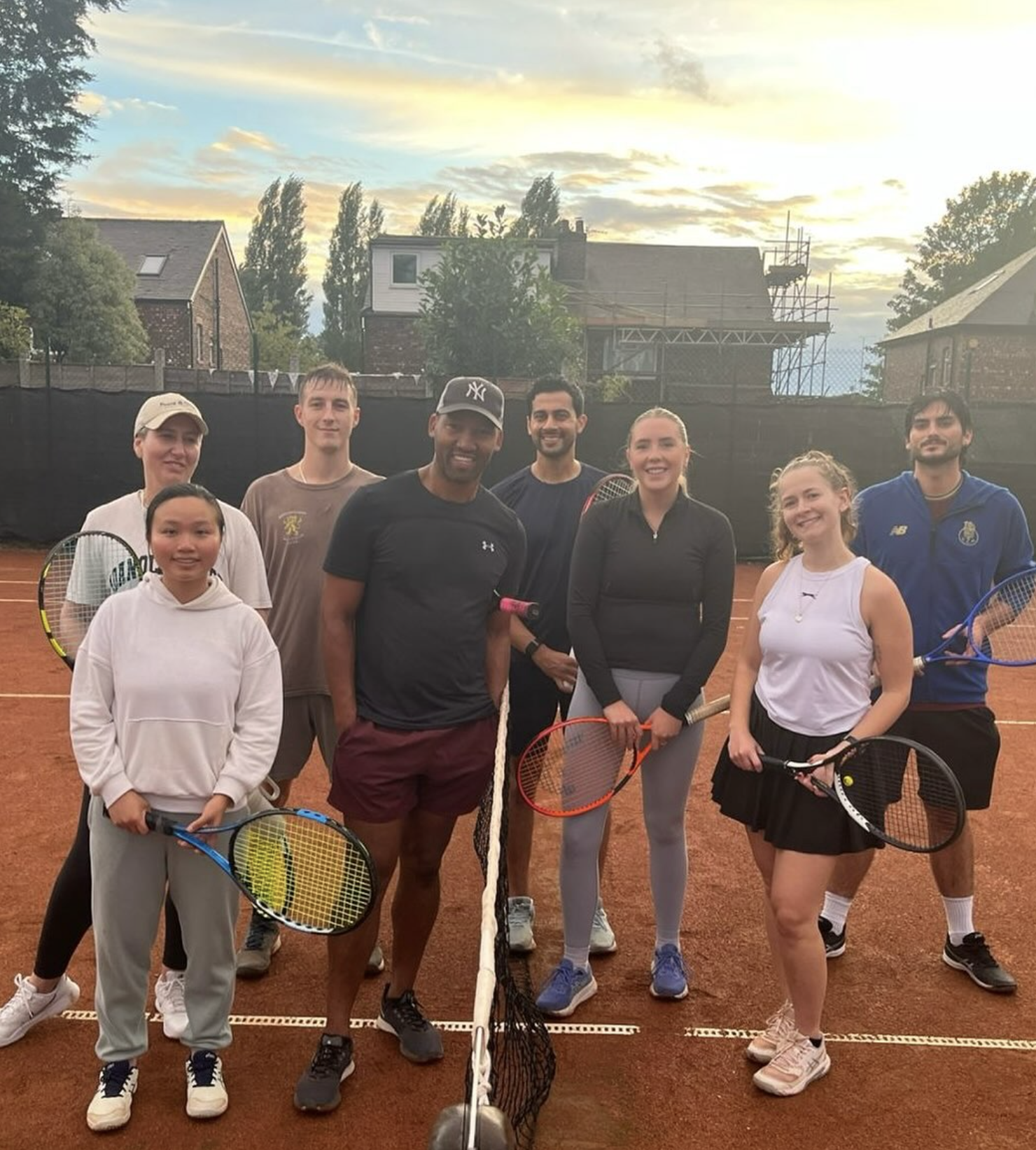 A group of Claremont players together on a clay tennis court
