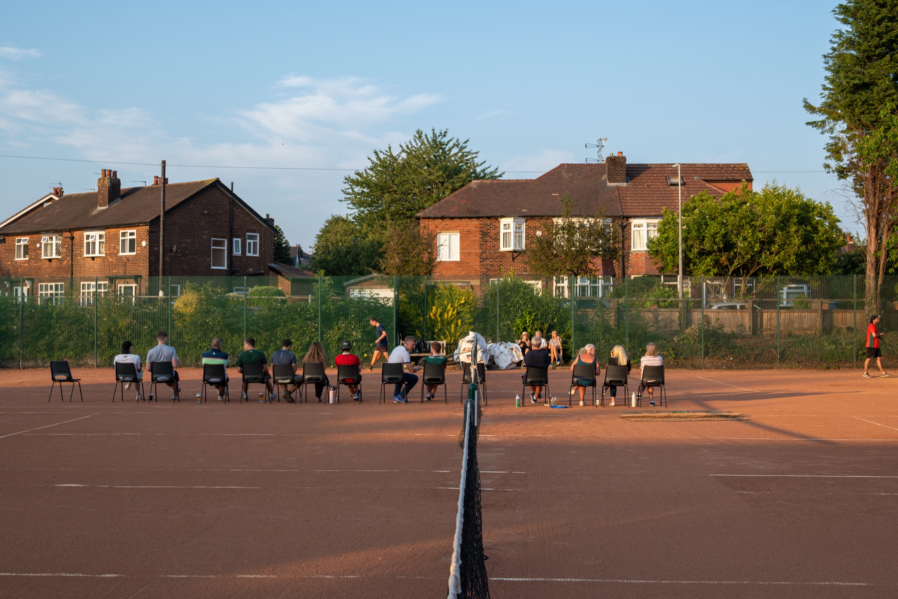 Members watching tennis from the courtside at Claremont