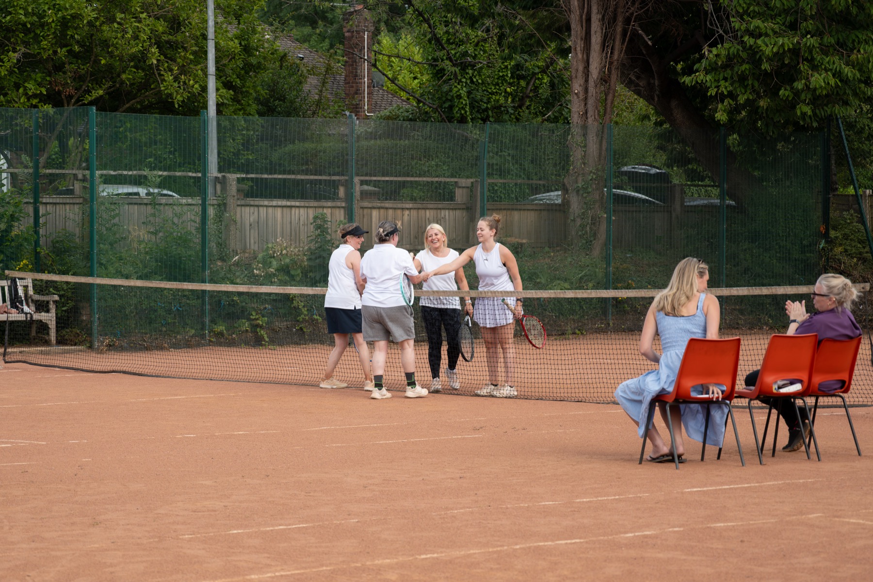 Women's doubles players at the net at Claremont